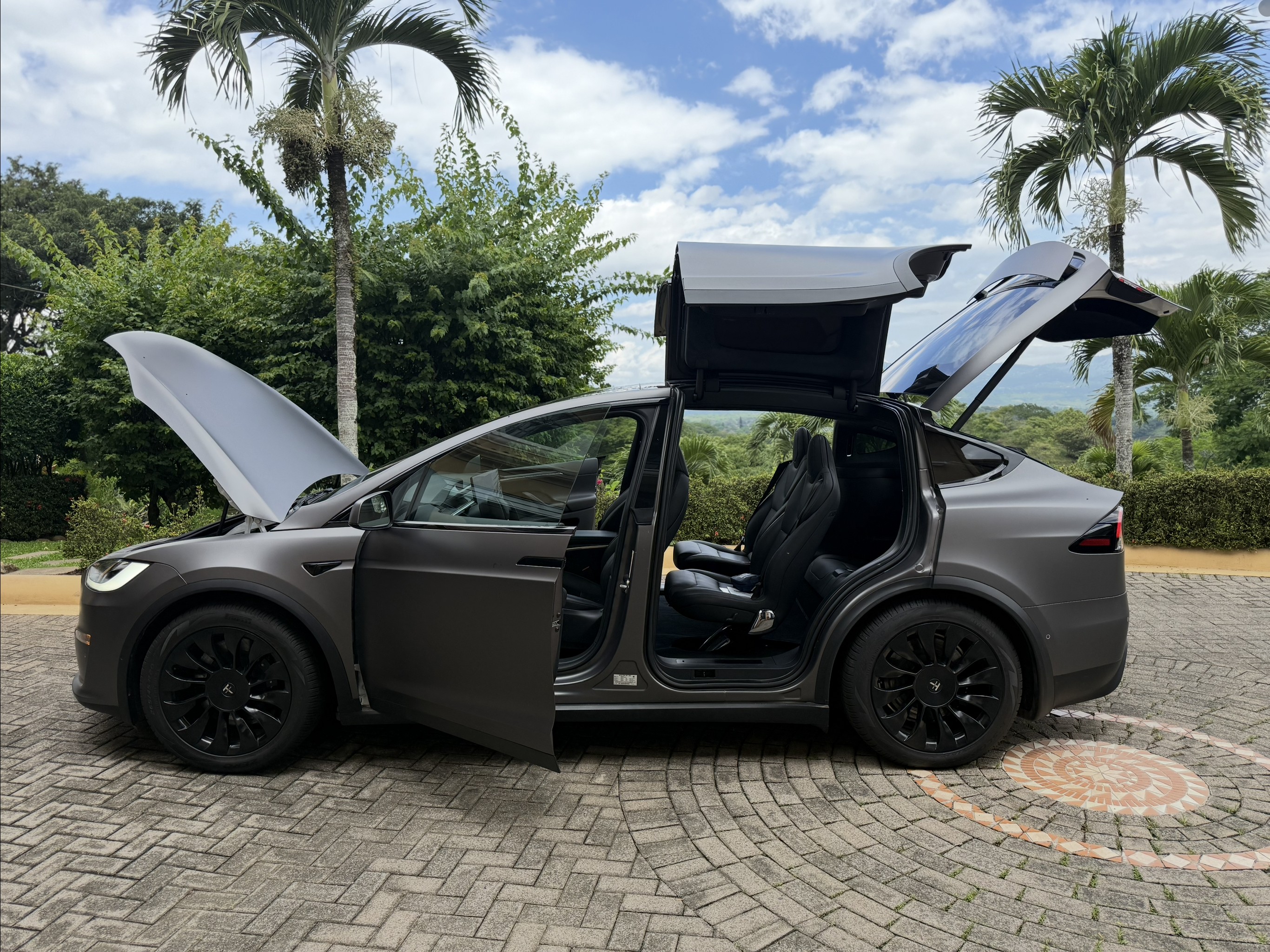 Tesla Model X Plaid passenger‑side view with doors and frunk open
